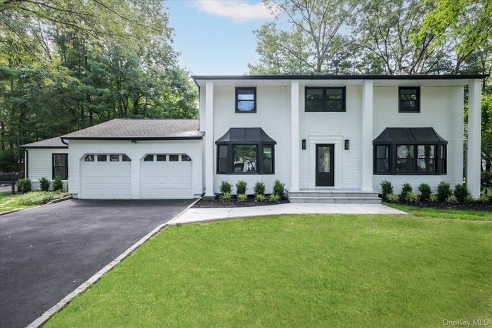 View of front facade with a garage, driveway, and a front yard