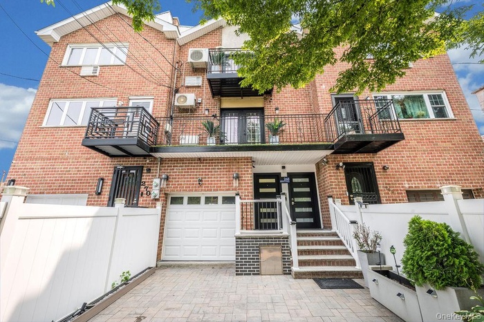 Traditional-style home with brick siding, an attached garage, and a balcony