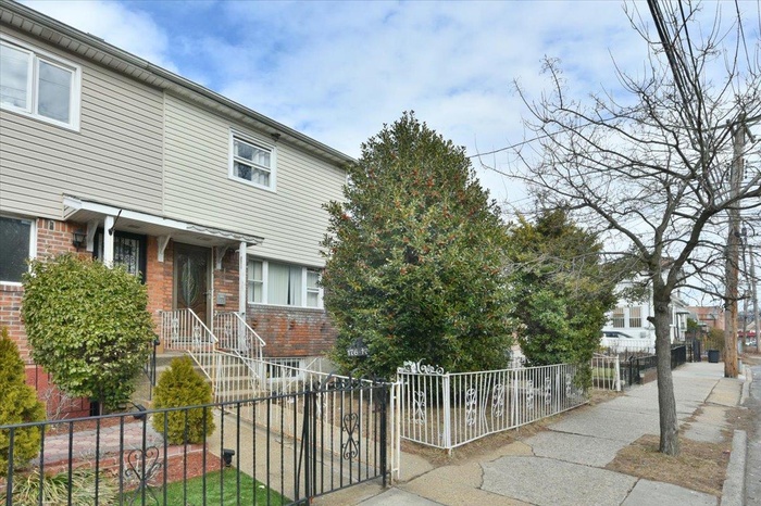View of property with brick siding and a fenced front yard