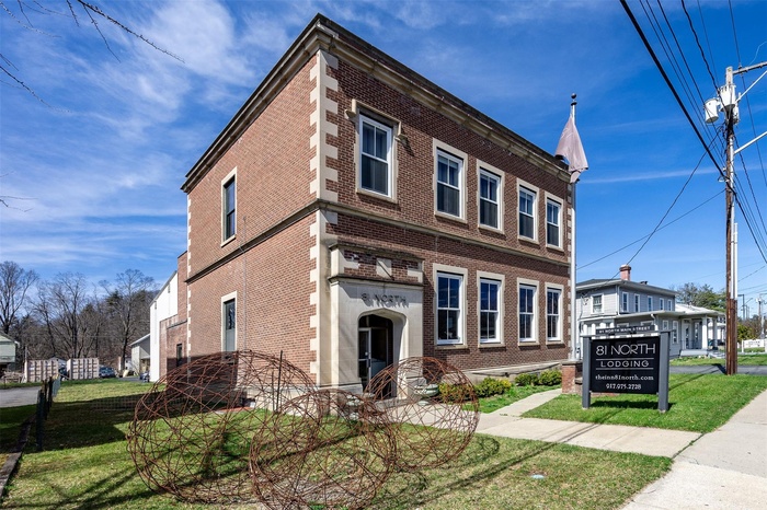 Townhome / multi-family property featuring brick siding and a front lawn