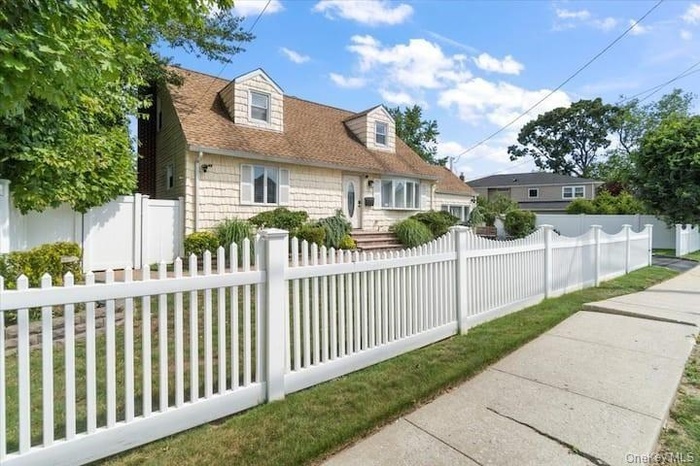 Cape cod-style house with a fenced front yard