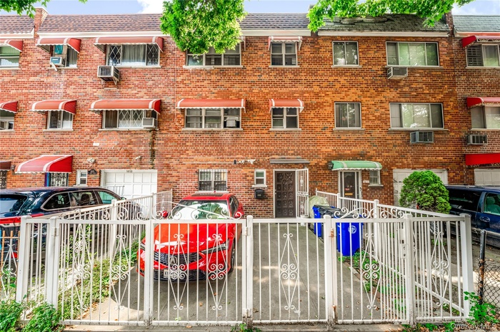 View of front facade featuring a fenced front yard, brick siding, a garage, and a gate