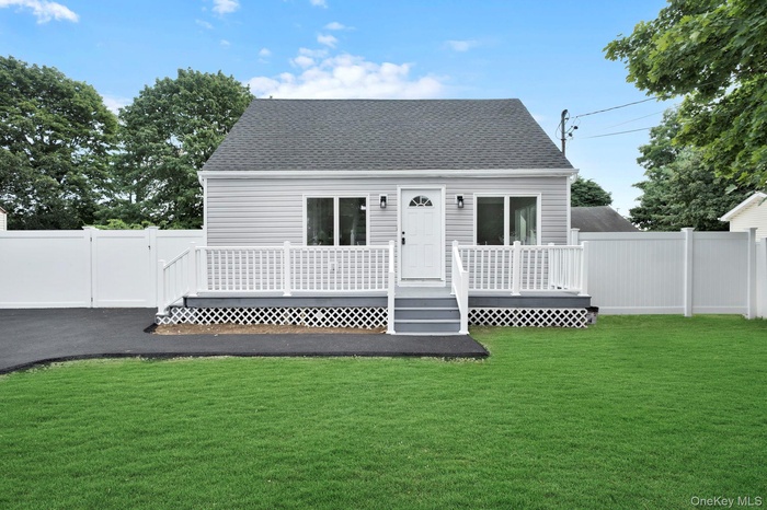 Rear view of house featuring a deck, roof with shingles, and a gate
