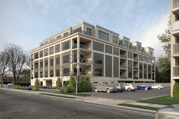 View of apartment building / complex featuring uncovered parking