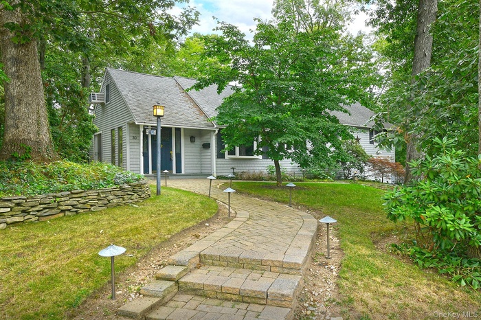 View of front of home featuring a shingled roof and a front lawn