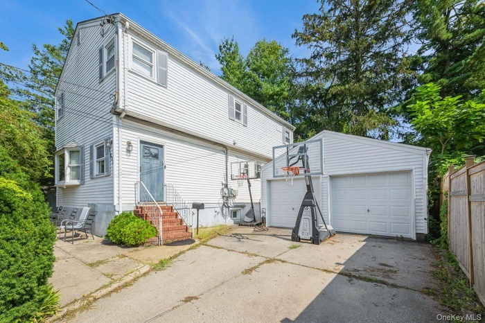 Back of property with an outbuilding, a detached garage, and entry steps