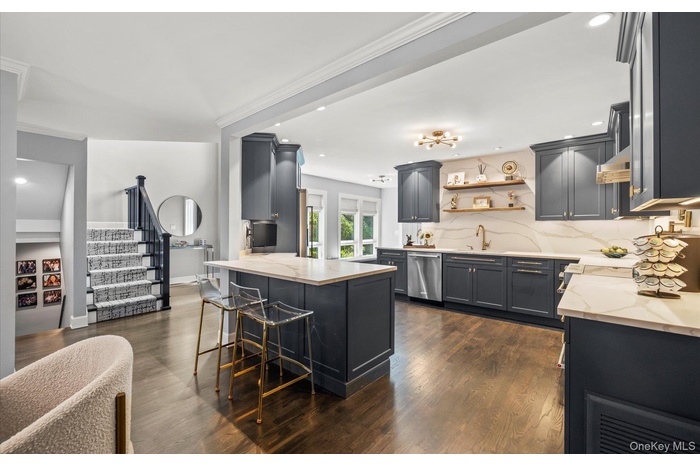 Kitchen featuring light stone counters, decorative backsplash, stainless steel dishwasher, open shelves, and recessed lighting
