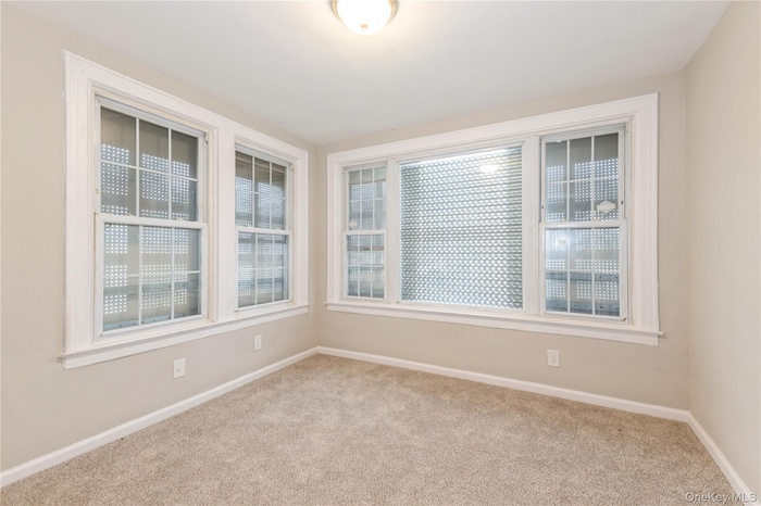 Carpeted spare room with baseboards