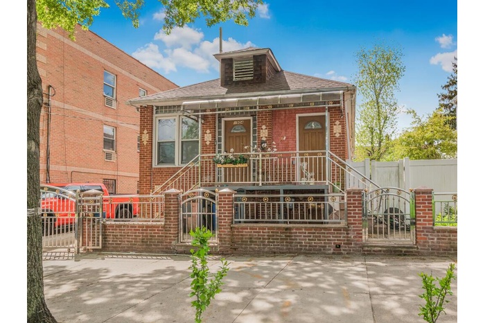 View of front facade featuring a gate, brick siding, and a fenced front yard