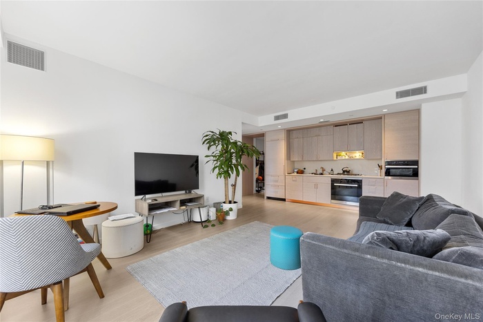 Living area with light wood-type flooring and recessed lighting