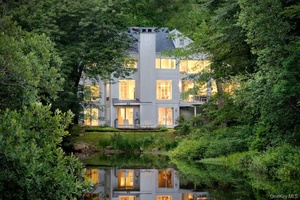 Tucked beside a peaceful pond in Pound Ridge, this contemporary retreat feels like living inside a work of art.