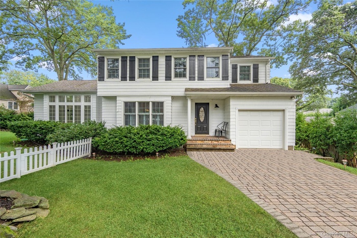 View of front of home featuring decorative driveway and a garage