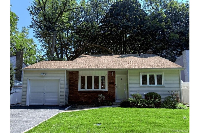 Ranch-style house with an attached garage, driveway, and brick siding