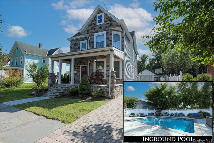 View of front of property featuring stone siding and covered porch