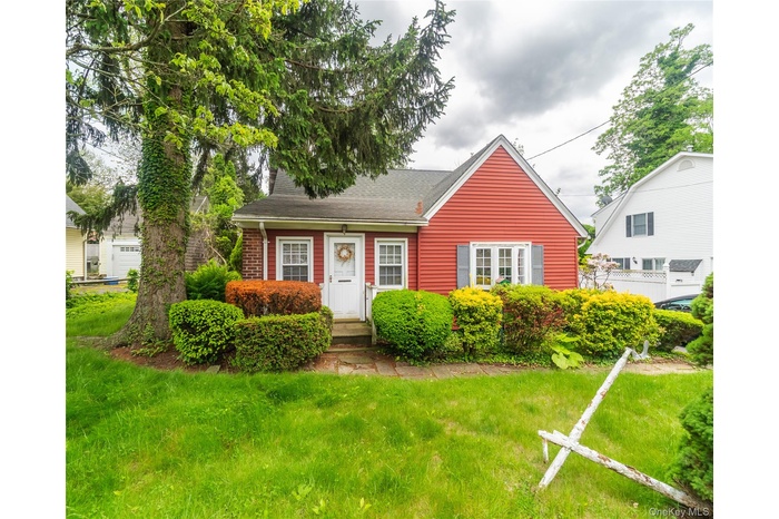 View of front of house featuring a front yard and a shingled roof
