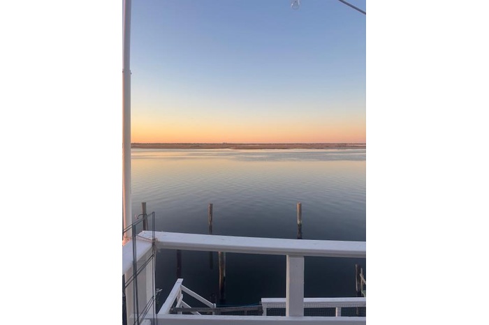 View of dock with a water view and a balcony