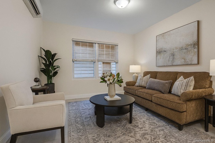 Living area with baseboards and a wall mounted air conditioner