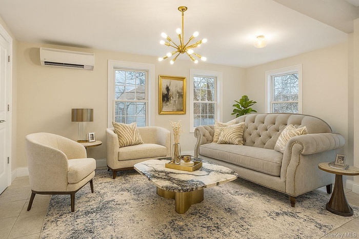 Living area with a chandelier, a wall unit AC, and light tile patterned floors