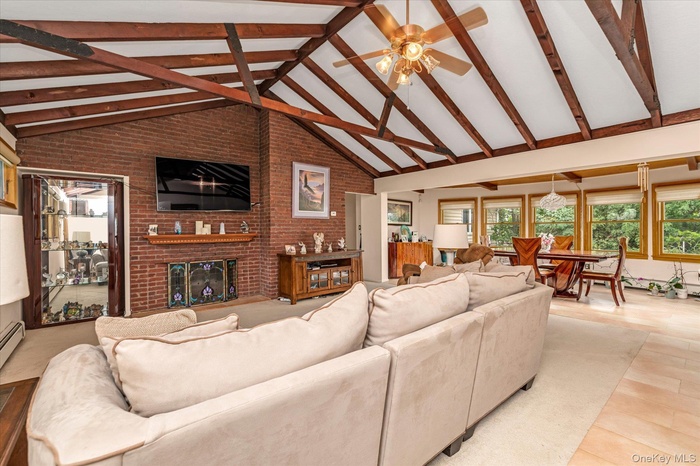 Brick wall, Fireplace, beam ceiling, ceiling fan, high vaulted ceiling