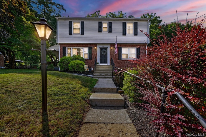 Colonial house featuring a front yard