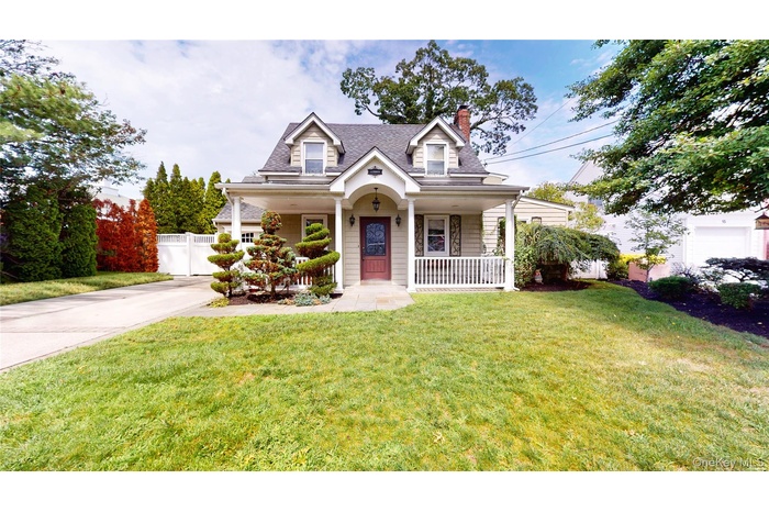 Cape cod home featuring a chimney, covered porch, and a shingled roof