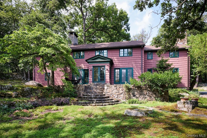 View of front of property featuring a chimney and a front lawn