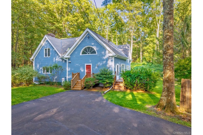 View of front of house with a front lawn and roof with shingles
