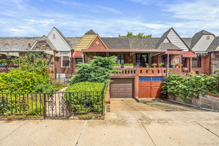 Tudor home featuring driveway, brick siding, a garage, and a porch