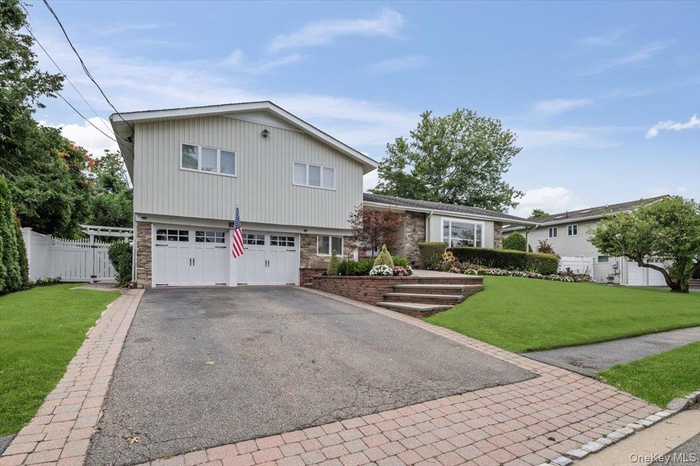 Split level home with asphalt driveway and an attached garage