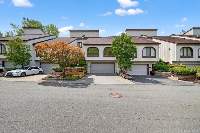 View of front of property with an attached garage and asphalt driveway