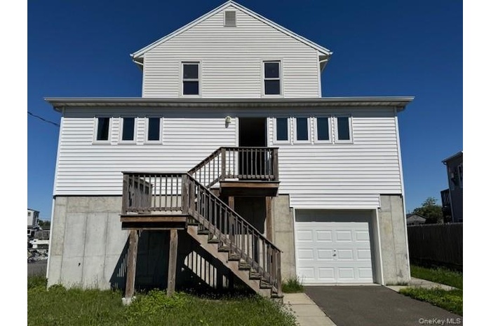 Rear view of house with an attached garage and driveway