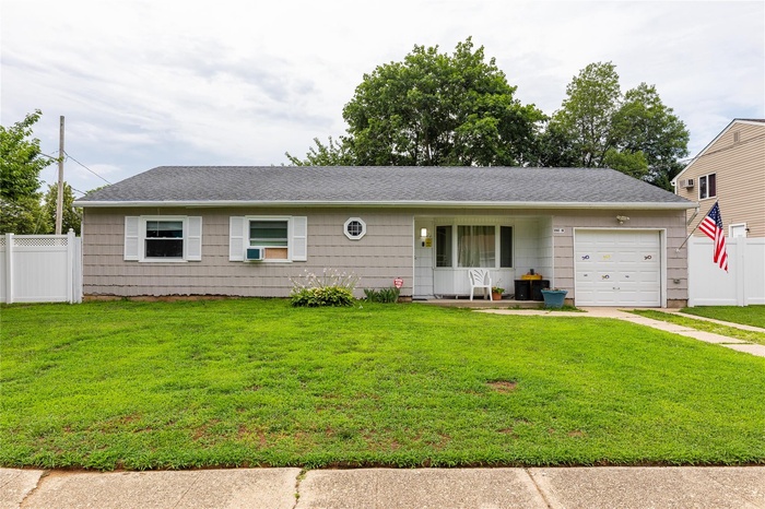 Single story home featuring a garage, concrete driveway, and roof with shingles