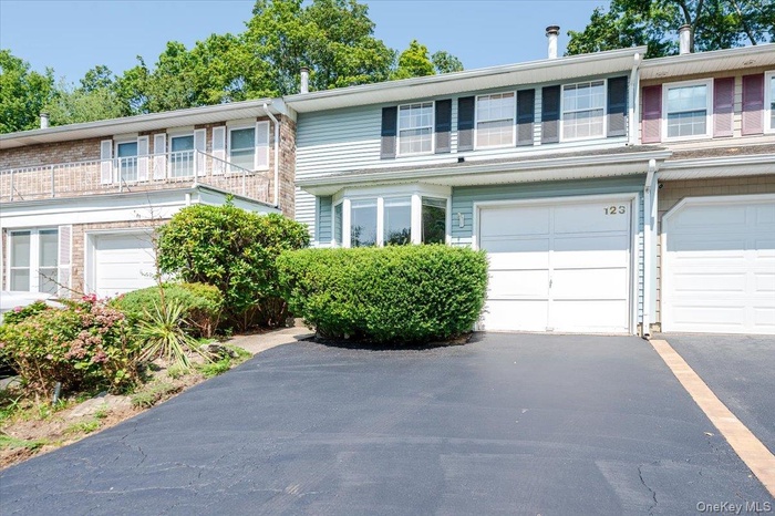 Traditional-style house featuring driveway, an attached garage, and a balcony