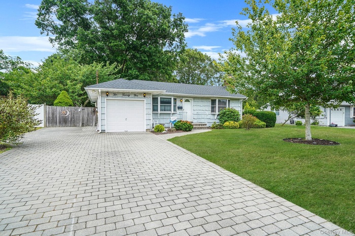 Ranch-style home with decorative driveway, a garage, and a chimney