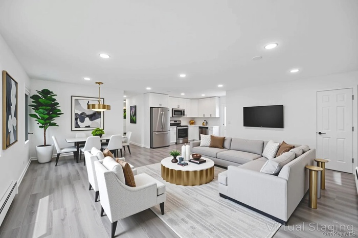 Living area featuring a baseboard heating unit, recessed lighting, and light wood-type flooring