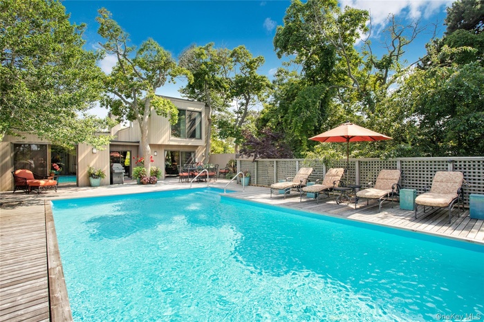 View of pool featuring a grill, a patio area, and a deck