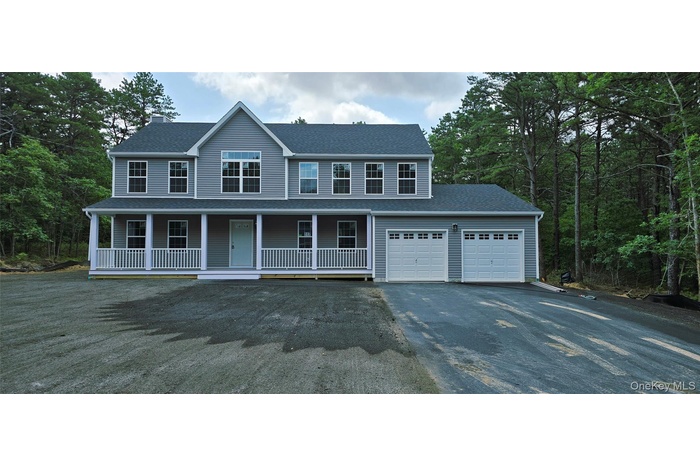 Colonial house with driveway, covered porch, roof with shingles, a chimney, and a garage