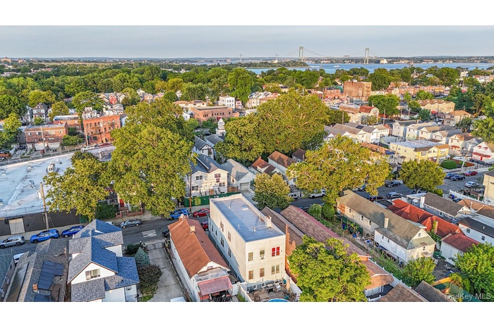 Aerial perspective of suburban area with a notable bridge and a large body of water