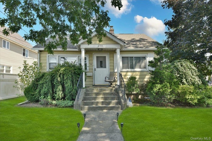 Bungalow-style house featuring a front lawn, a chimney, and roof with shingles