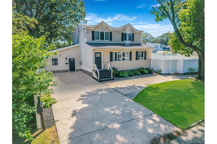 concrete driveway, covered porch, and a shingled roof