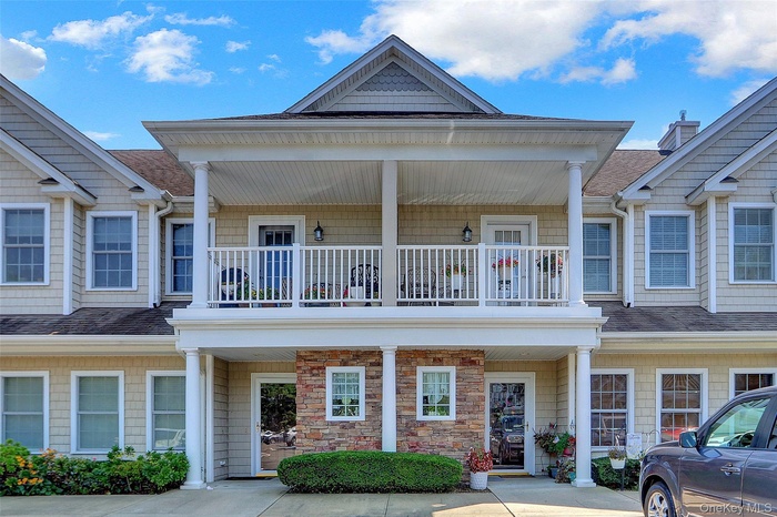 View of front of property with a shingled roof and a balcony