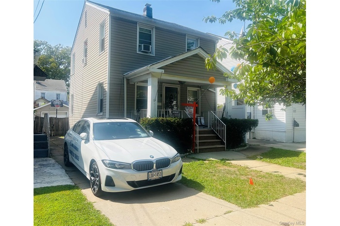 View of front facade featuring a porch and a chimney
