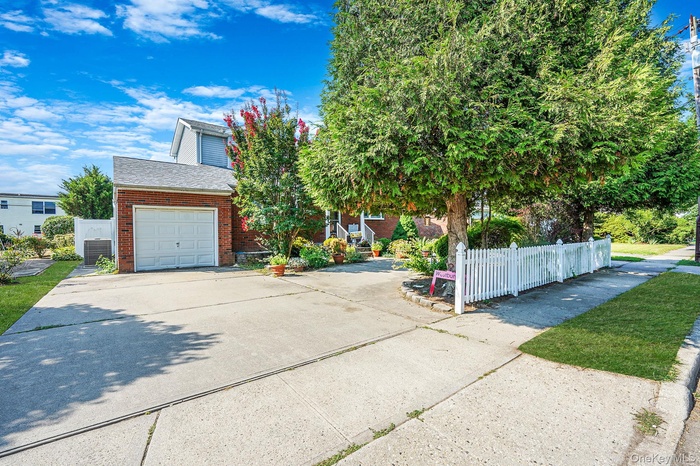 View of front of house featuring concrete driveway, brick siding, a garage, and a shingled roof