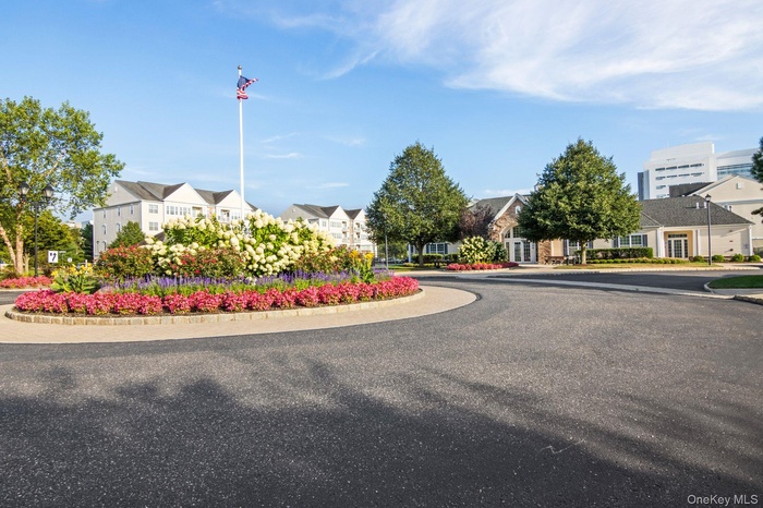 View of asphalt road featuring a residential view, street lights, and curbs