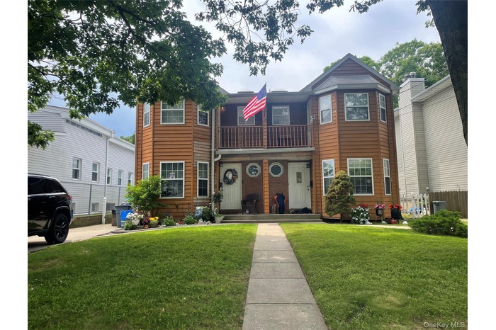 Traditional-style home with a front lawn and a balcony