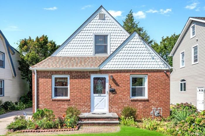 View of front of property with brick siding and roof with shingles
