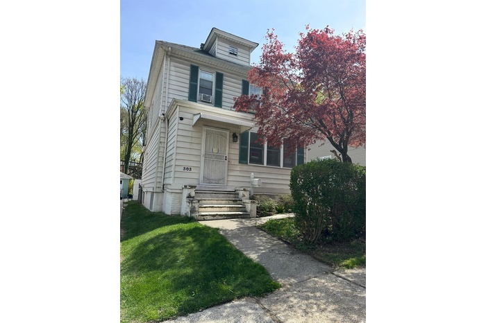 American foursquare style home featuring a front lawn