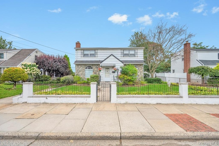 View of front of house featuring a fenced front yard, a gate, and a chimney