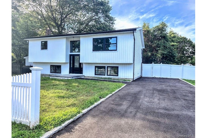 Split foyer home featuring driveway and a chimney