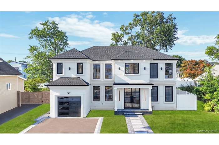 View of front of property featuring roof with shingles, driveway, stucco siding, and a garage